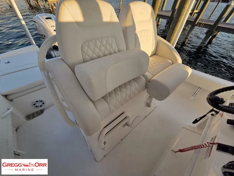 Slide: The Image of 2025 Regulator 26XO Crossover boat seats with quilted design, dockside view. - 10