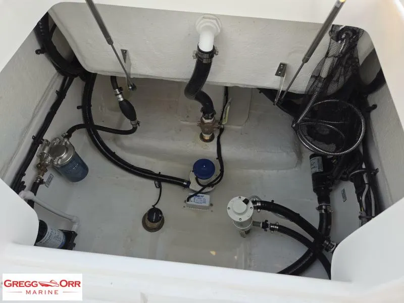 Slide: The Image of 2025 Regulator 26XO Crossover boat interior with visible plumbing and wiring components. - 17