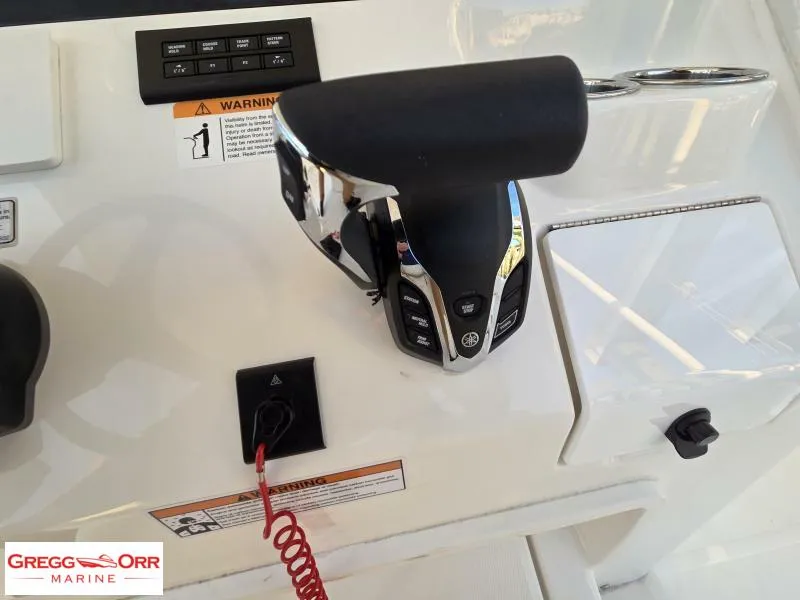 Slide: The Image of Control panel of 2025 Regulator 26XO CROSSOVER boat with throttle and warning labels. - 18