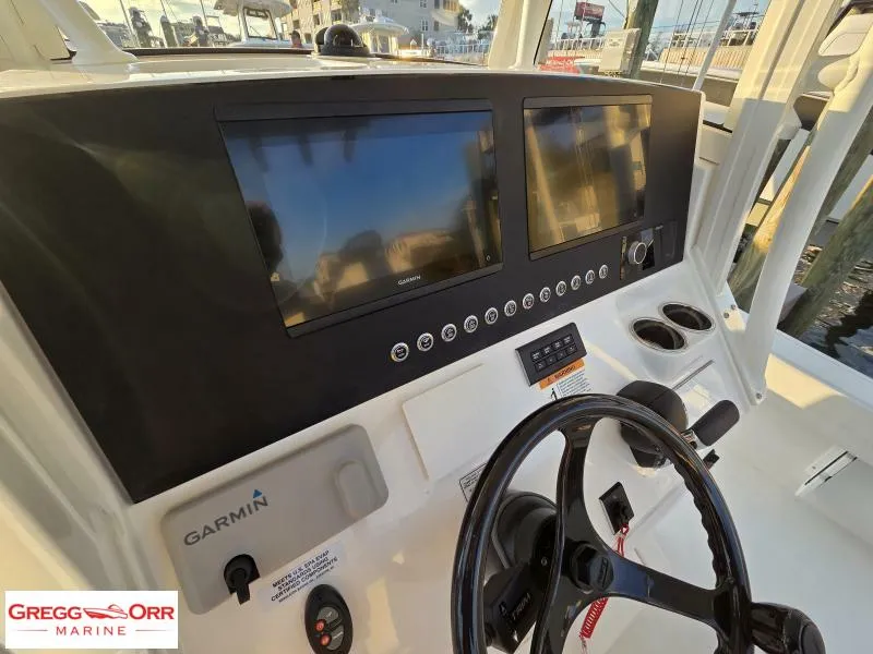 Slide: The Image of 2025 Regulator 26XO Crossover boat dashboard with Garmin displays and steering wheel. - 19