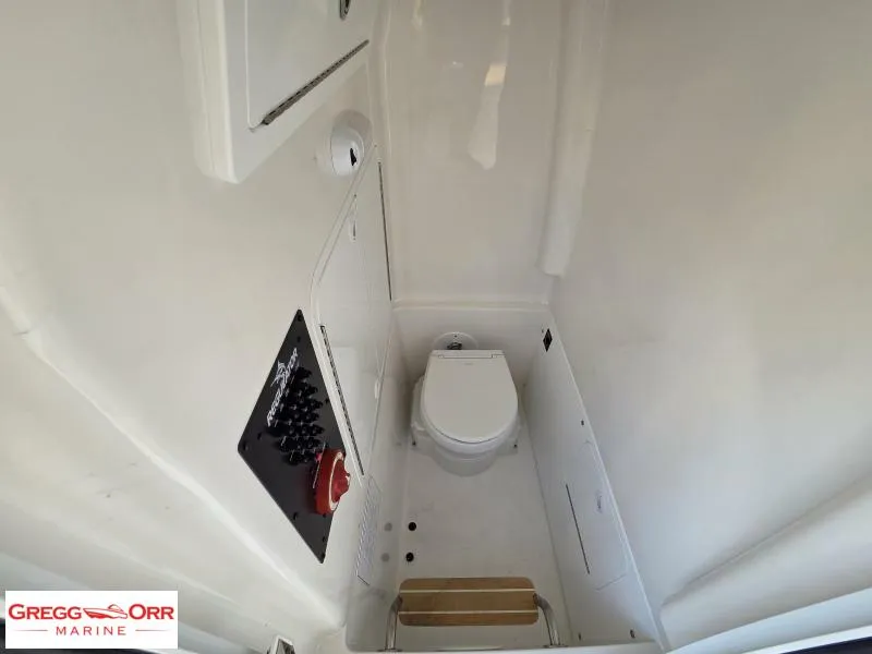 Slide: The Image of 2025 Regulator 26XO Crossover boat interior with compact marine toilet. - 20