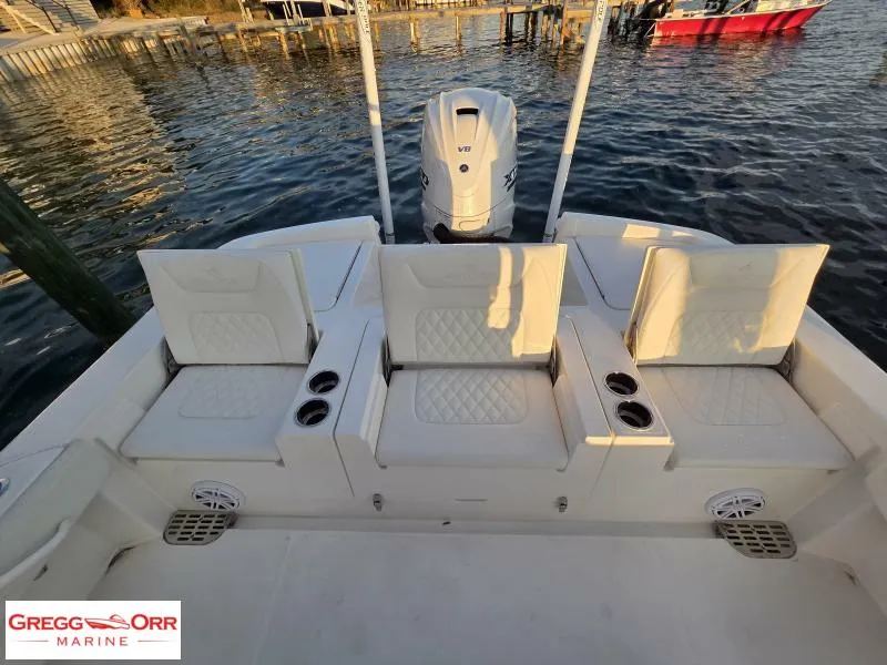 Slide: The Image of 2025 Regulator 26XO CROSSOVER boat with seating and outboard motor, docked on calm water. - 6