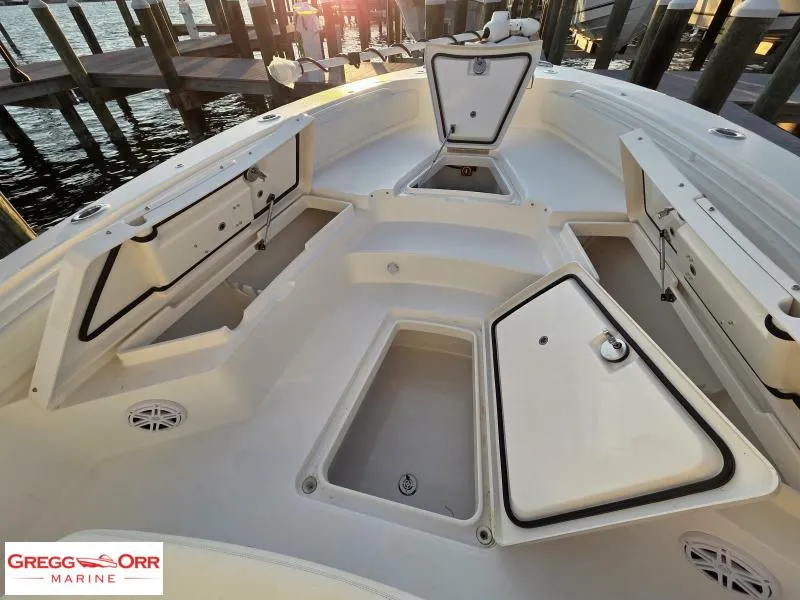 Slide: The Image of 2025 Regulator 26XO Crossover boat interior with open storage compartments at sunset. - 8