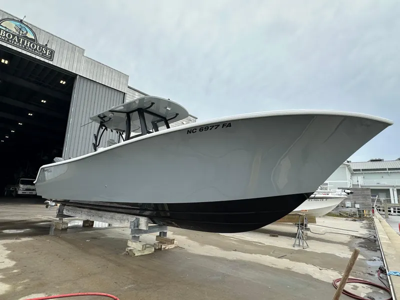 Slide: The Image of 2023 Front Runner 33 Center Console boat outside a boathouse. - 2