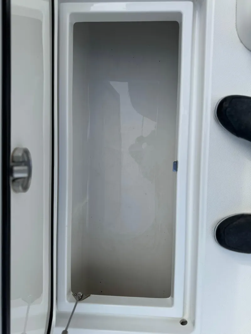 Slide: The Image of 2023 Front Runner 33 Center Console storage compartment, open and empty. - 23