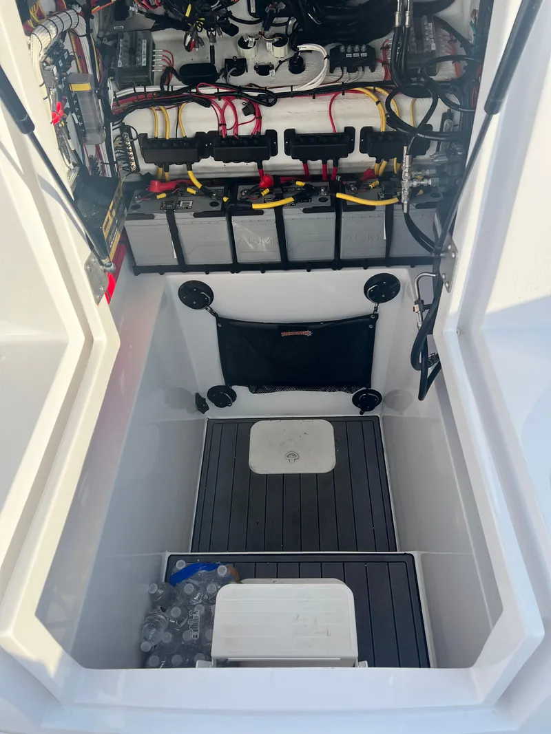 Slide: The Image of 2023 Front Runner 33 Center Console boat storage compartment with organized wiring and equipment. - 24