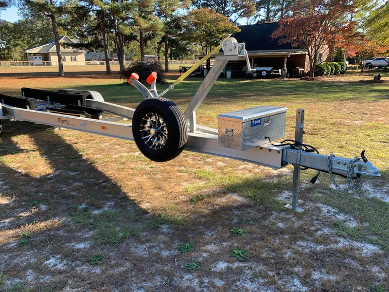 Slide: The Image of 2023 Front Runner 33 Center Console trailer in a sunny yard setting. - 37