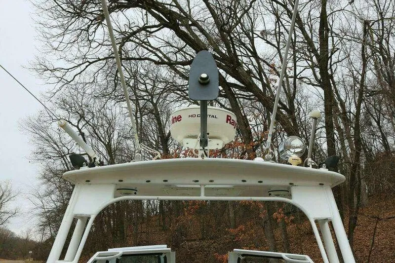 Slide: The Image of SeaArk 25 V Commander SAMA 1365 boat, 2002 model, with radar and antennas, surrounded by trees. - 24