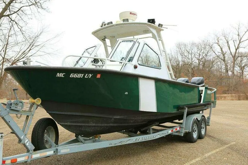 Slide: The Image of 2002 SeaArk 25 V Commander SAMA 1365 boat on trailer, parked outdoors. - 28