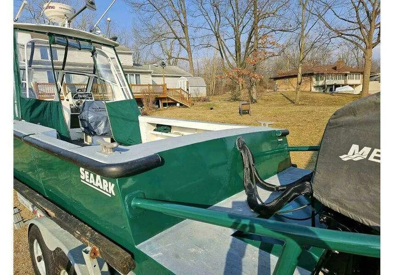 Slide: The Image of 2002 SeaArk 25 V Commander SAMA 1365 boat on trailer, parked in a yard. - 31