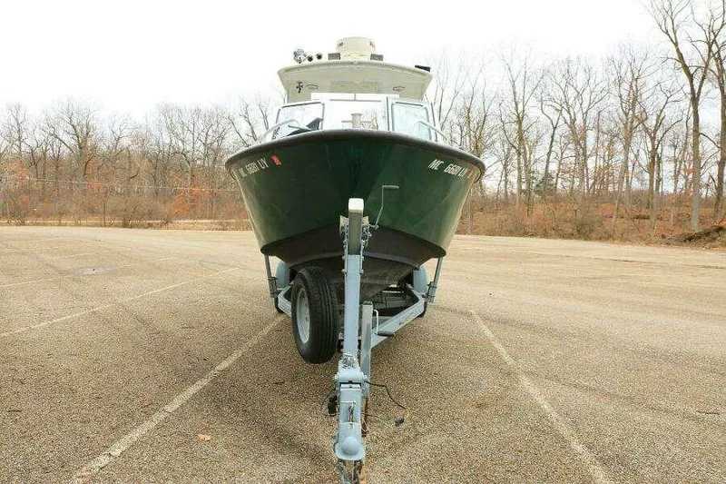Slide: The Image of 2002 SeaArk 25 V Commander SAMA 1365 boat on trailer in parking lot. - 6