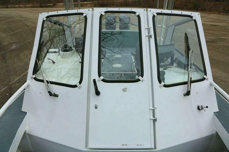 Slide: The Image of SeaArk 25 V Commander SAMA 1365 boat windshield and cabin, 2002 model, parked outdoors. - 8
