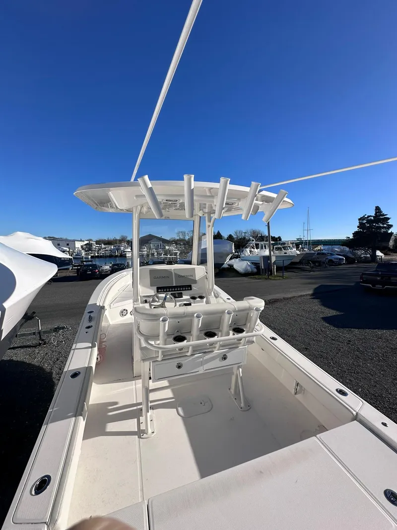 Slide: The Image of 2024 Regulator 24XO boat with center console and rod holders, docked under clear blue sky. - 10
