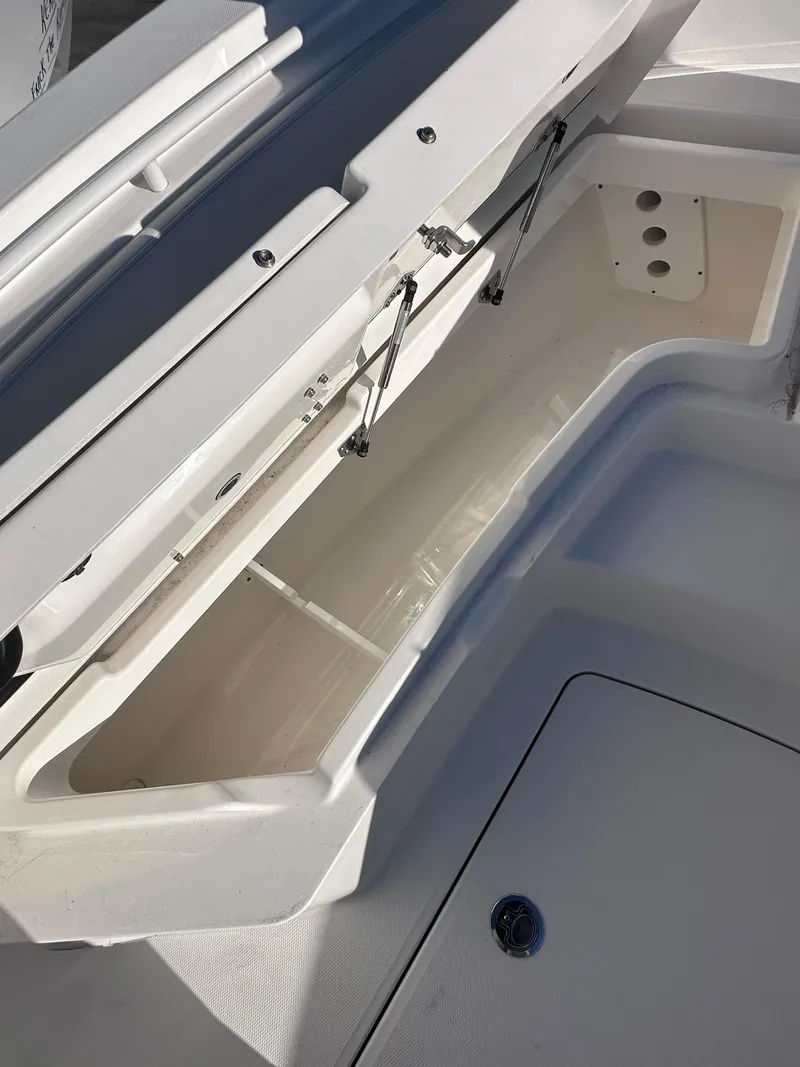 Slide: The Image of 2024 Regulator 24XO boat storage compartment with open lid, showcasing spacious interior. - 13
