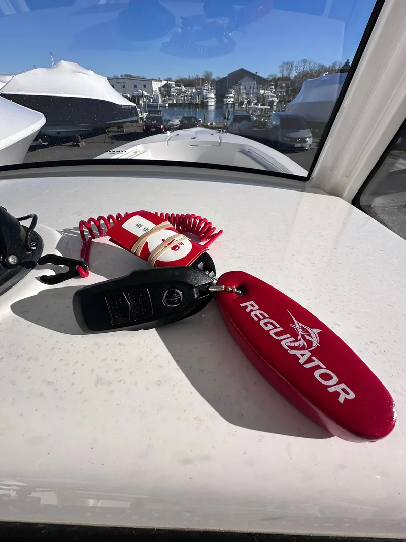 Slide: The Image of 2024 Regulator 24XO boat keys on dashboard with marina view. - 14