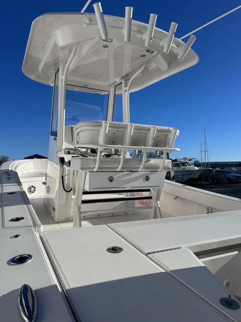 Slide: The Image of 2024 Regulator 24XO boat with T-top and rod holders under clear blue sky. - 3