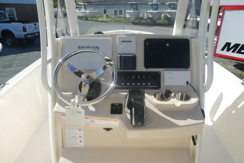 Slide: The Image of 2025 Boston Whaler 220 Dauntless boat console with steering wheel and controls. - 10