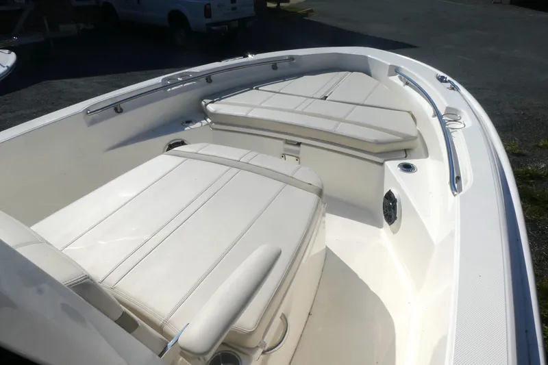 Slide: The Image of 2025 Boston Whaler 220 Dauntless boat interior with cushioned seating and sleek design. - 12