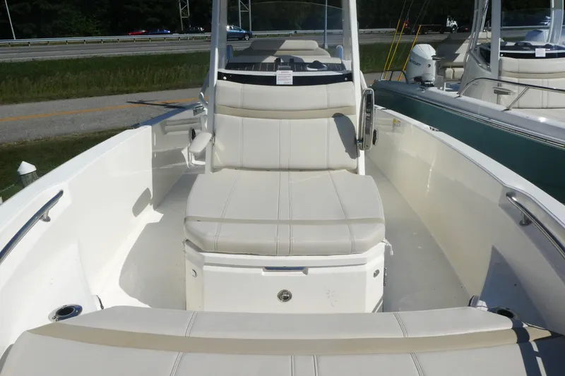 Slide: The Image of 2025 Boston Whaler 220 Dauntless boat interior with white seating and console. - 13