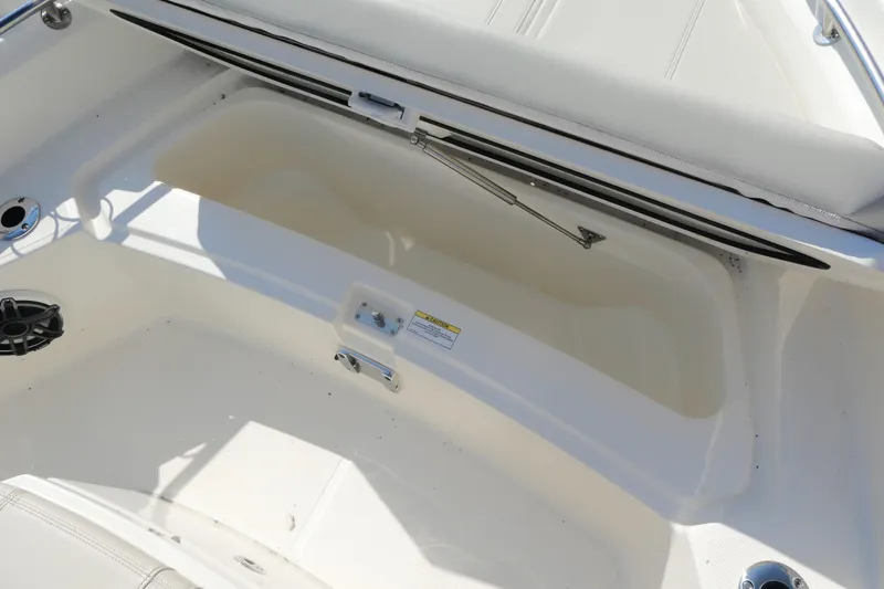 Slide: The Image of 2025 Boston Whaler 220 Dauntless boat storage compartment with open lid and speaker. - 15