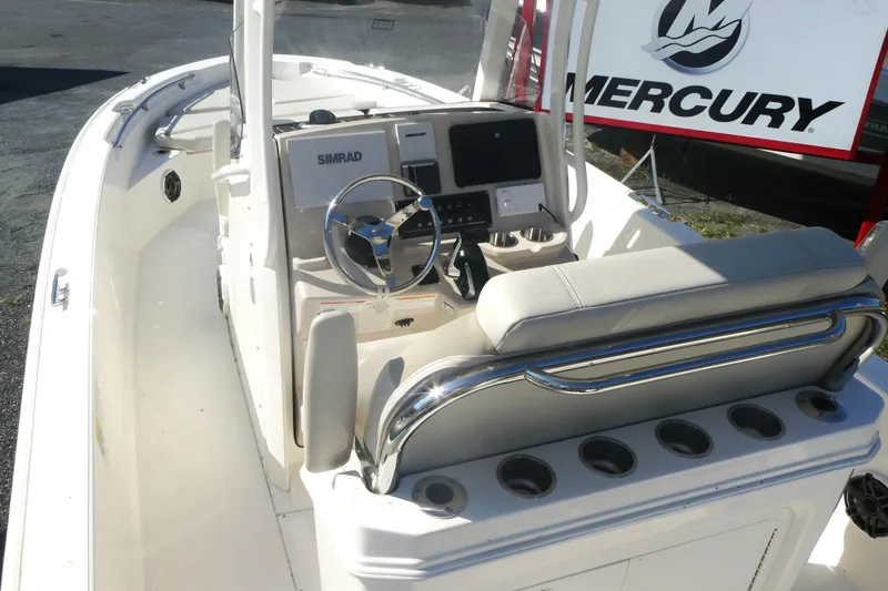 Slide: The Image of 2025 Boston Whaler 220 Dauntless boat interior with Simrad navigation system and Mercury branding. - 5