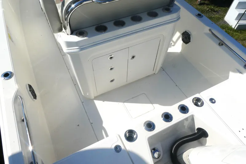 Slide: The Image of 2025 Boston Whaler 220 Dauntless boat interior with storage compartments and rod holders. - 6