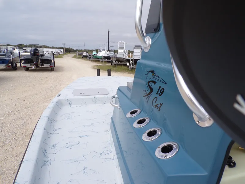 Slide: The Image of Shoalwater 19 CAT 2025 boat with sleek design in a marina setting. - 22