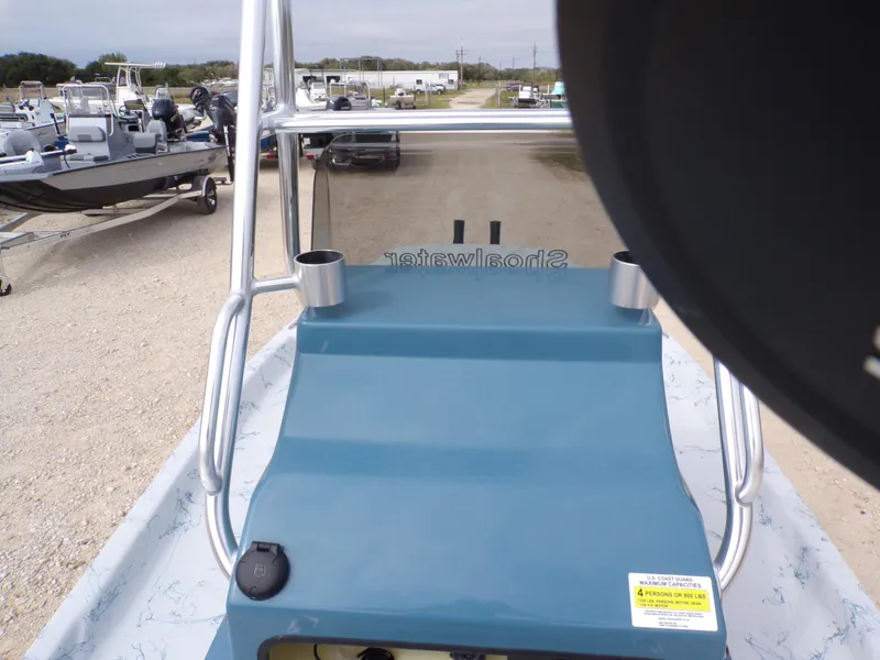 Slide: The Image of 2025 Shoalwater 19 CAT boat console with cup holders, parked on gravel lot. - 24