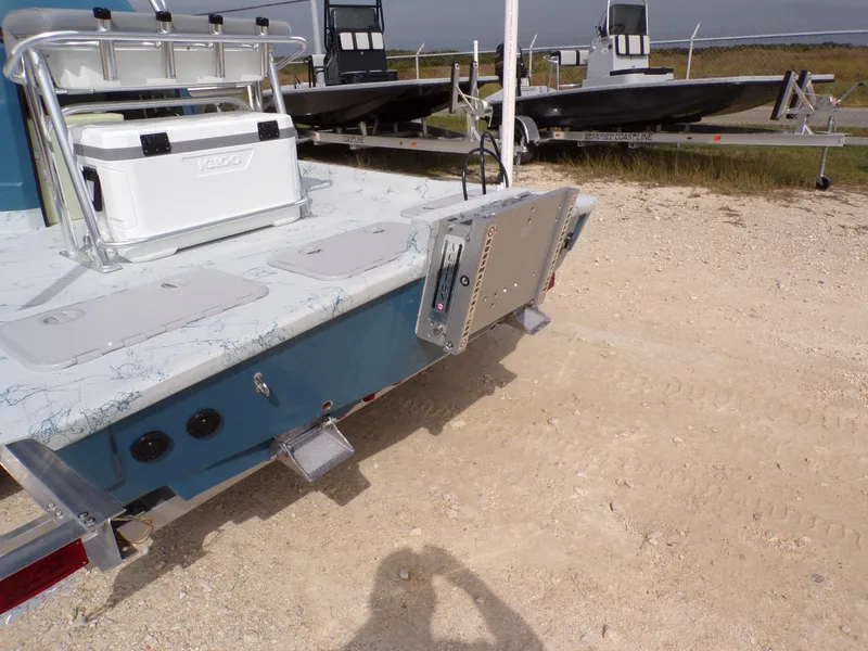Slide: The Image of 2025 Shoalwater 19 CAT boat with Igloo cooler on deck, parked on gravel. - 30