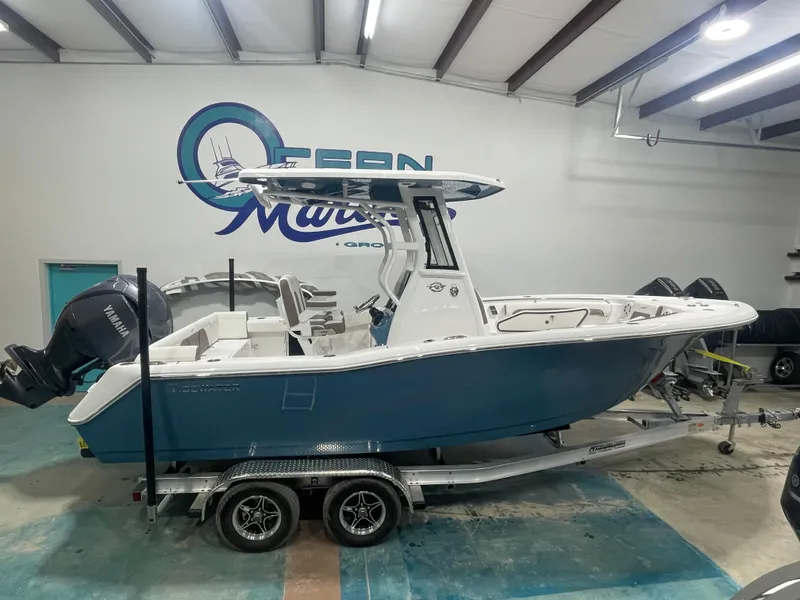 Slide: The Image of 2025 Tidewater 232LXF boat on trailer in showroom with Yamaha engine. - 1