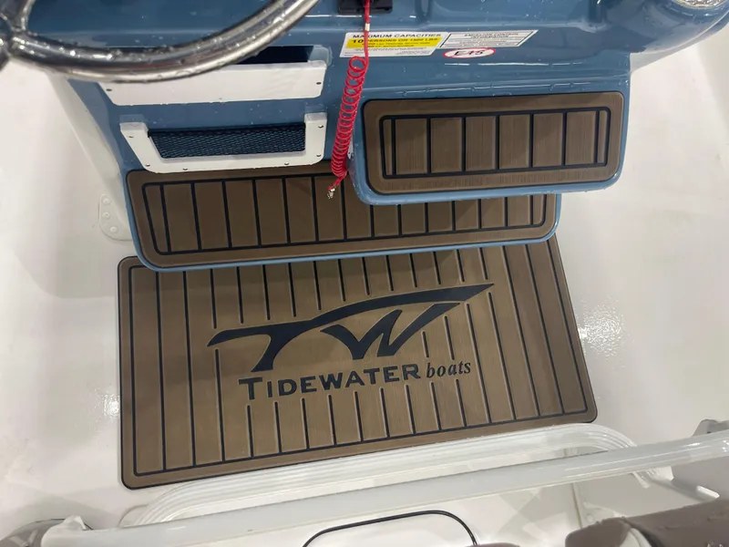 Slide: The Image of Tidewater 232LXF 2025 boat interior with branded floor mat and console details. - 23
