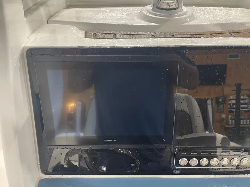Slide: The Image of Garmin display on 2025 Tidewater 232LXF boat dashboard with compass and control buttons. - 27