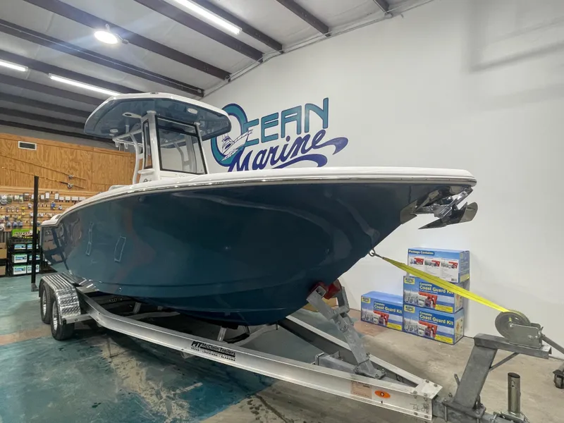 Slide: The Image of 2025 Tidewater 232LXF boat on trailer in showroom, Ocean Marine logo in background. - 3