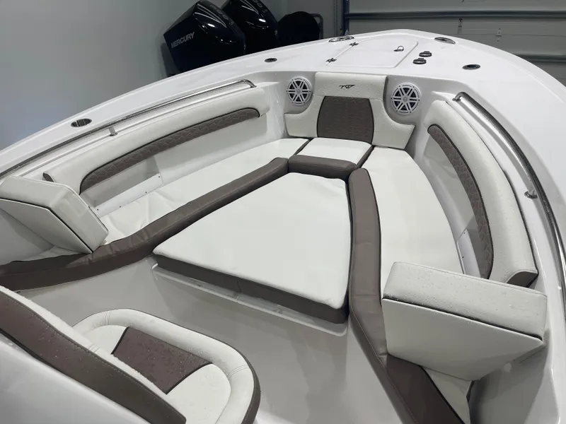 Slide: The Image of 2025 Tidewater 232LXF boat interior with cushioned seating and speakers. - 37