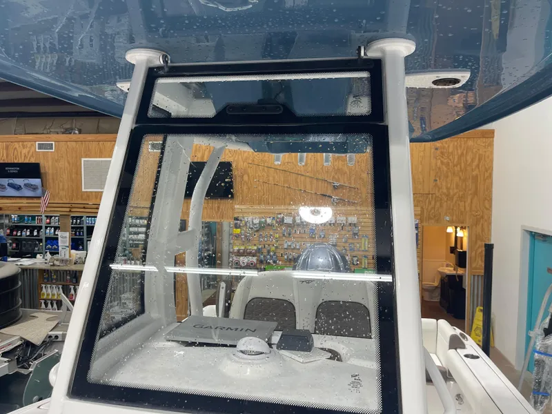 Slide: The Image of 2025 Tidewater 232LXF boat interior with Garmin navigation system, displayed in a showroom. - 39