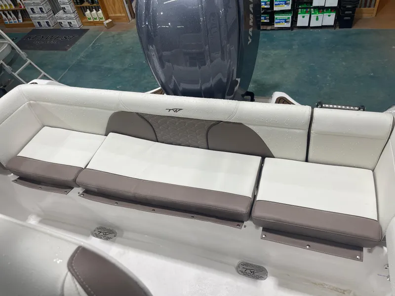 Slide: The Image of 2025 Tidewater 232LXF boat interior with cushioned seating and Yamaha engine in showroom. - 41