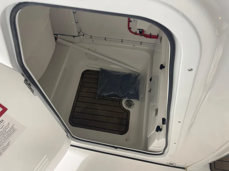 Slide: The Image of 2025 Tidewater 232LXF boat storage compartment with wooden flooring and drainage. - 42