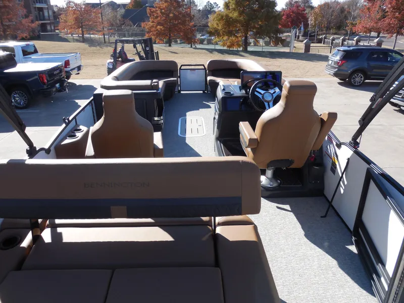 Slide: The Image of 2025 Bennington 26 MSB pontoon boat interior with tan seating and steering console. - 14