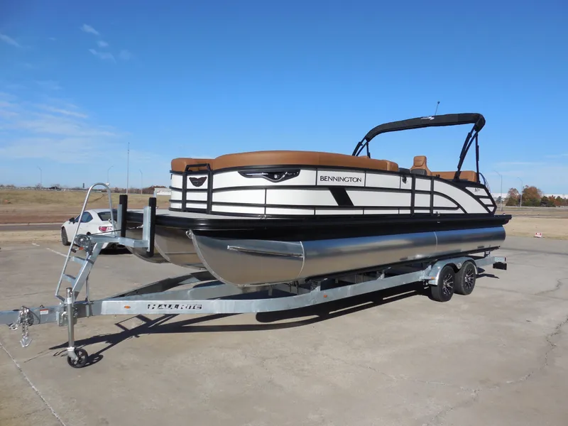Slide: The Image of 2025 Bennington 26 MSB pontoon boat on trailer under clear blue sky. - 6