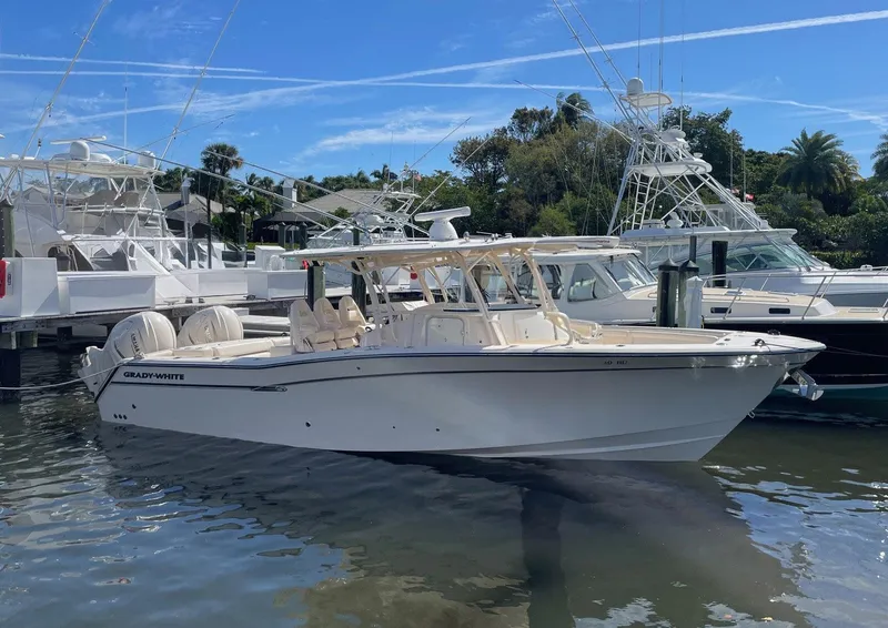 Slide: The Image of 2019 Grady-White Canyon 336 boat docked in a marina under a clear blue sky. - 1