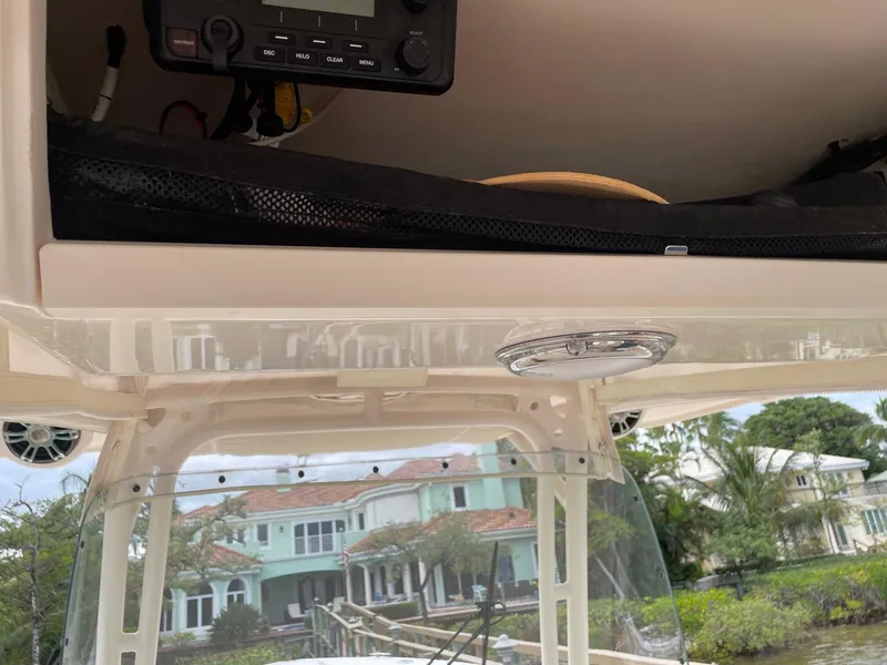 Slide: The Image of 2019 Grady-White Canyon 336 boat console with electronics, docked near waterfront homes. - 12