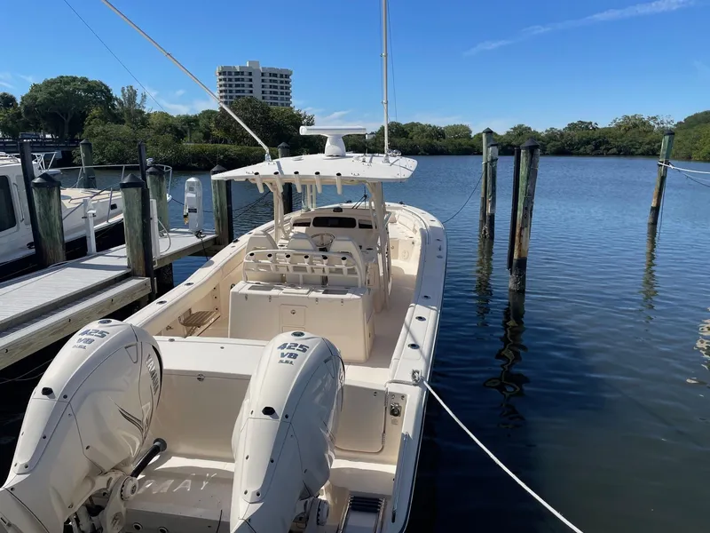 Slide: The Image of 2019 Grady-White Canyon 336 boat docked by a serene waterfront. - 17