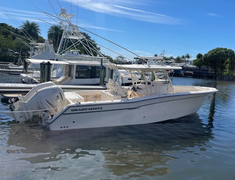 Slide: The Image of 2019 Grady-White Canyon 336 boat docked on calm water under a clear blue sky. - 2