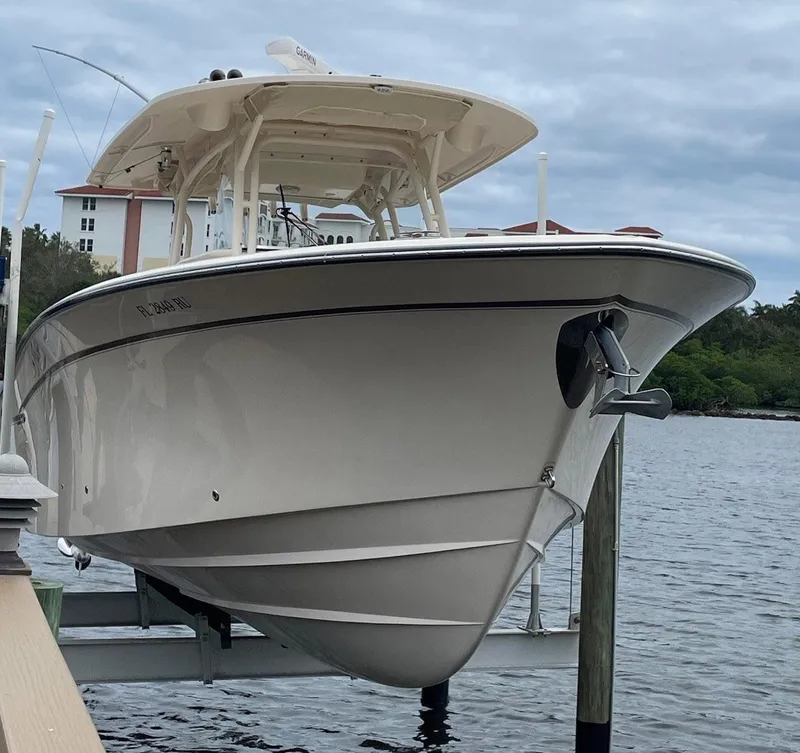 Slide: The Image of 2019 Grady-White Canyon 336 boat docked on a lift by the water. - 3