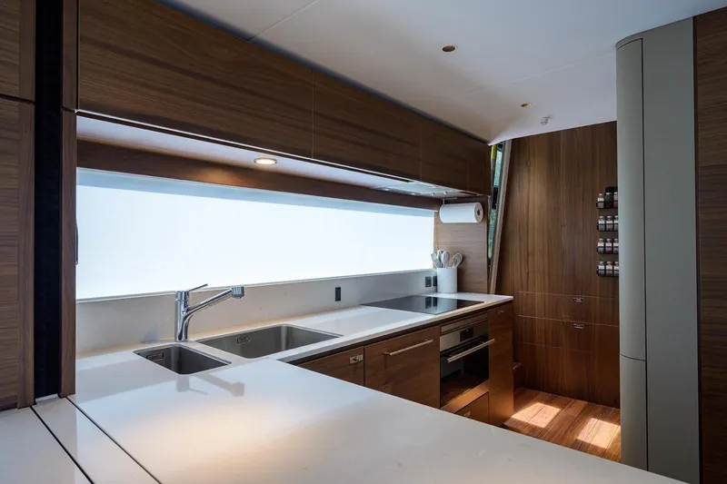 Slide: The Image of Luxurious kitchen interior on 2022 Princess Y85 Motor Yacht with modern wood cabinetry. - 25