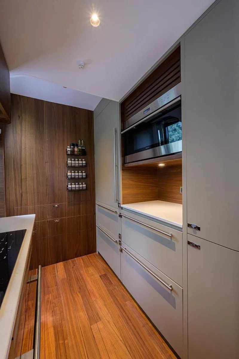 Slide: The Image of Modern kitchen interior on 2022 Princess Y85 Motor Yacht with sleek cabinetry and wood flooring. - 27
