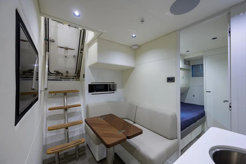 Slide: The Image of Interior of 2022 Princess Y85 Motor Yacht with modern seating and compact kitchen area. - 48