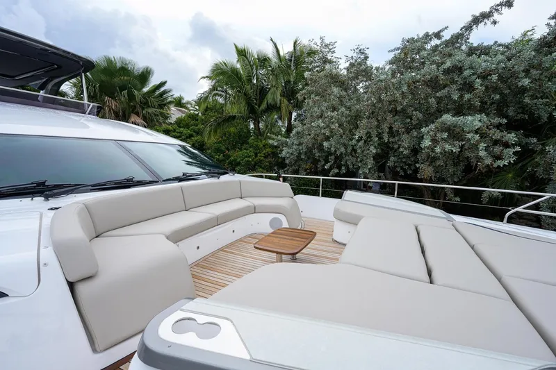 Slide: The Image of Luxurious 2022 Princess Y85 Motor Yacht deck with plush seating and tropical backdrop. - 7