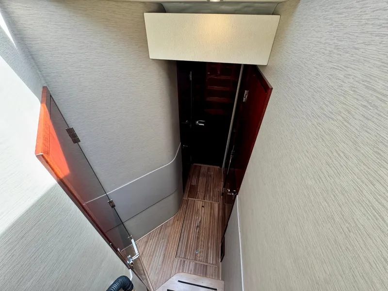 Slide: The Image of 2017 Sea Ray L590 yacht interior hallway with wooden flooring and modern design. - 20