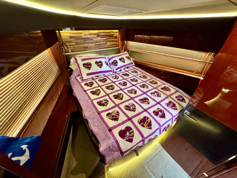 Slide: The Image of Luxurious 2017 Sea Ray L590 yacht cabin with heart-patterned bedding and ambient lighting. - 21